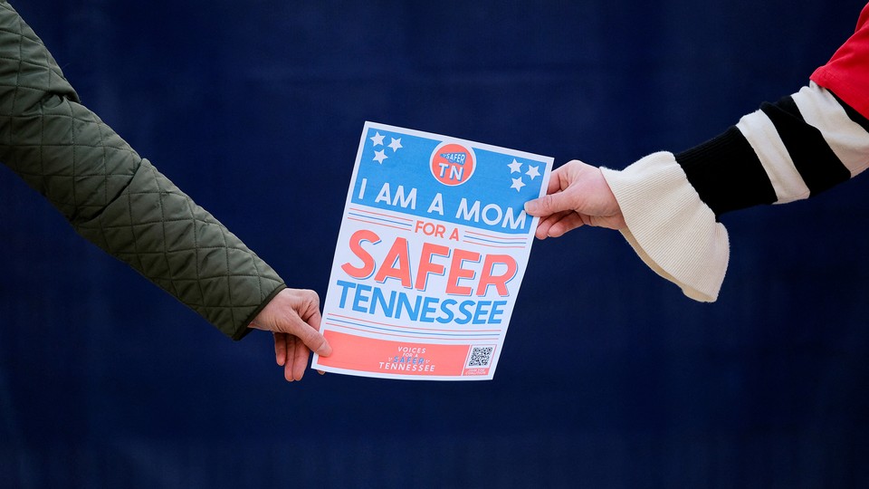 Women hold a sign as they form a human chain on the first anniversary of the Covenant School shooting in Nashville, Tennessee, March 27, 2024.