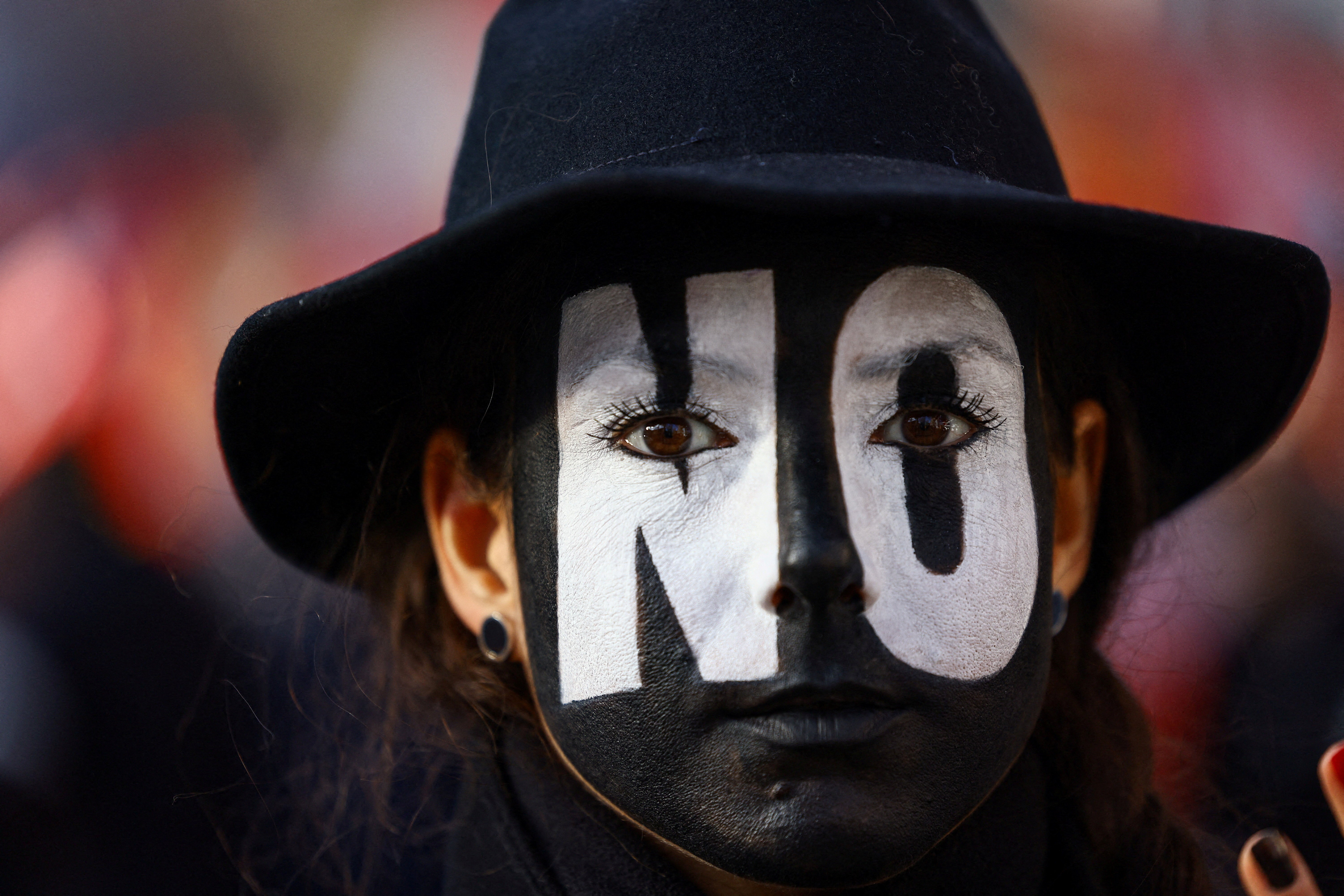 A demonstrator with the word 'No' painted across their face