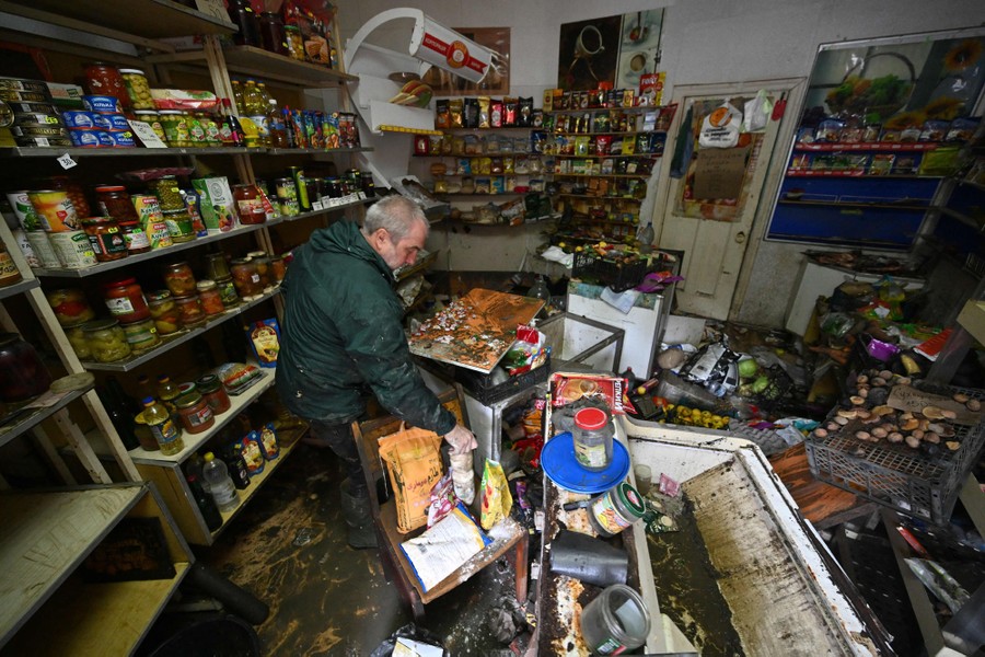 A person cleans inside a flood-damaged grocery store.