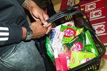 A person carries a grocery basket of KitKats.