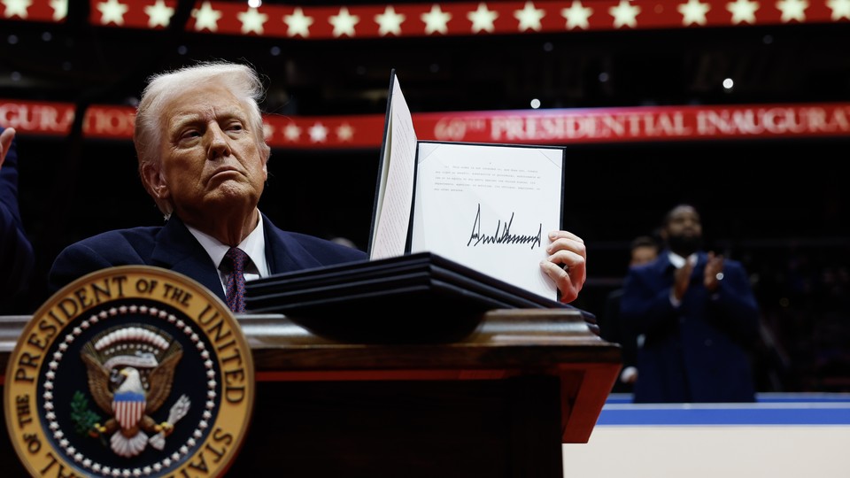 Trump holds up a signed executive order