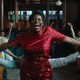 Fantasia Barrino wearing a red dress and red lipstick in "The Color Purple"
