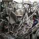A man looks at the shell of a bus that had been destroyed in a Saudi air strike in Yemen.