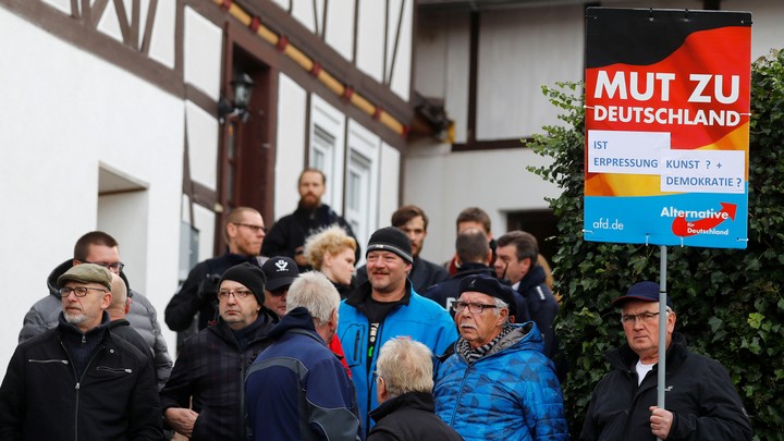 Alternative für Deutschland hold signs outside a Holocaust memorial.