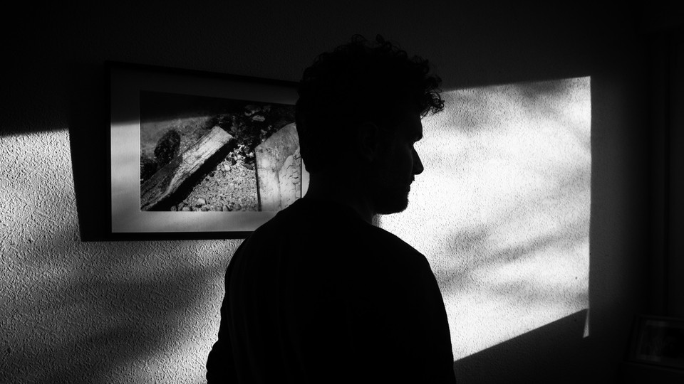 A black-and-white silhouette of a man in a room