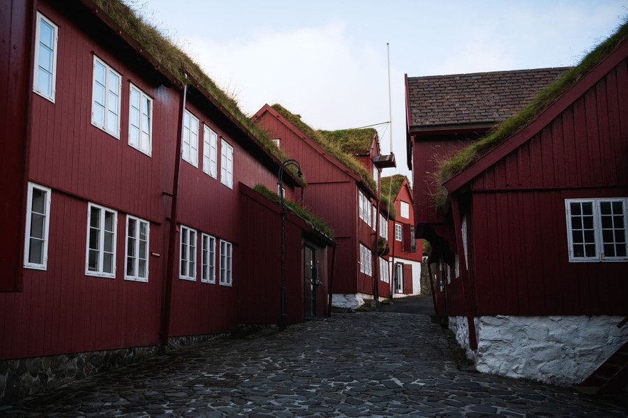 Historic wooden buildings stand along a cobblestone street.