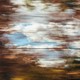 A blurred view out at a blue sky and autumnal tees
