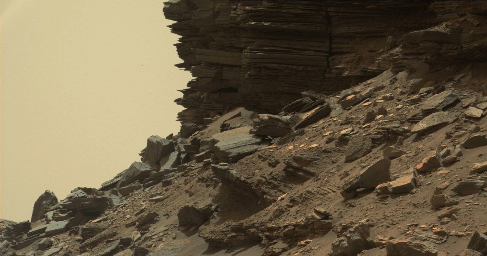 Sharp-edged rock layers are exposed on a cliffside