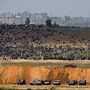 Israeli military vehicles are seen Friday next to the border on the Israeli side of the Israel-Gaza border, as Palestinians demonstrate in Gaza.