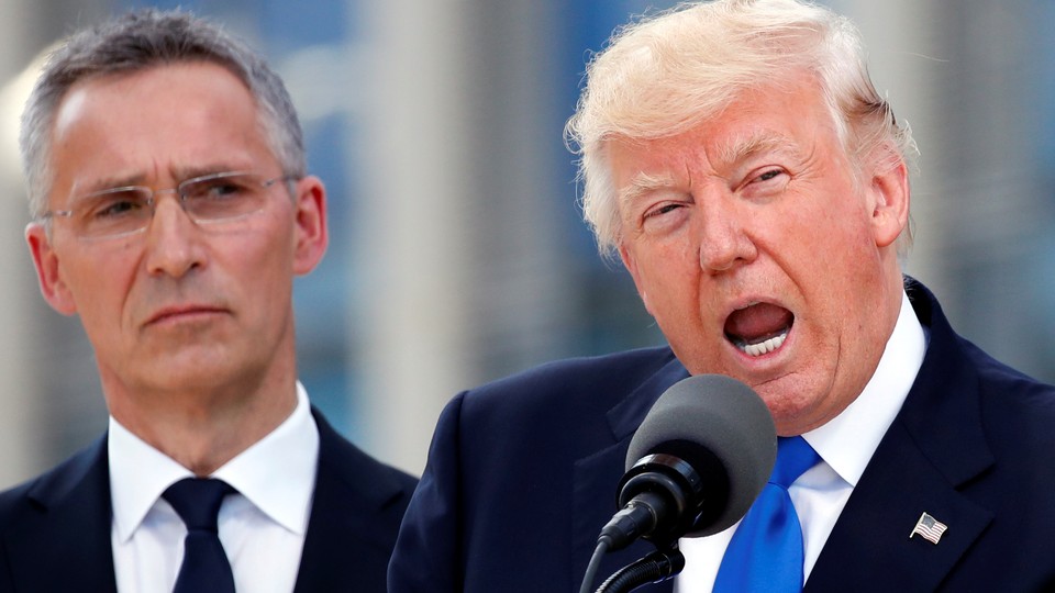 President Donald Trump speaks beside NATO Secretary General Jens Stoltenberg at the start of the NATO summit. 