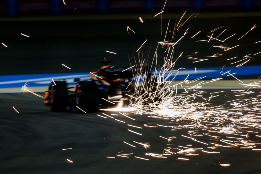 Sparks fly behind a speeding F1 race car.