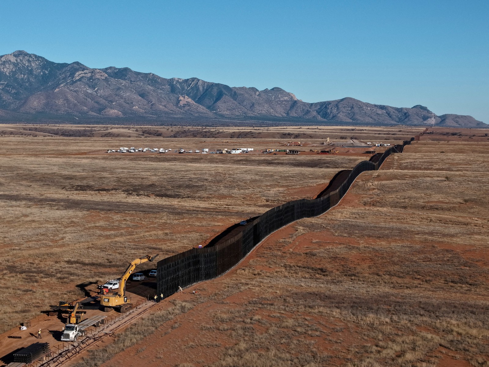 A drone view of a new section of border wall being constructed in an Arizona desert