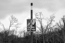 Campaign sign on a pole in a wooded area