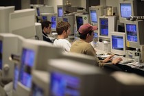 Three young men in a room full of computers