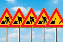 A set of five construction signs with a construction worker on each. The last sign shows the worker running away from his work.