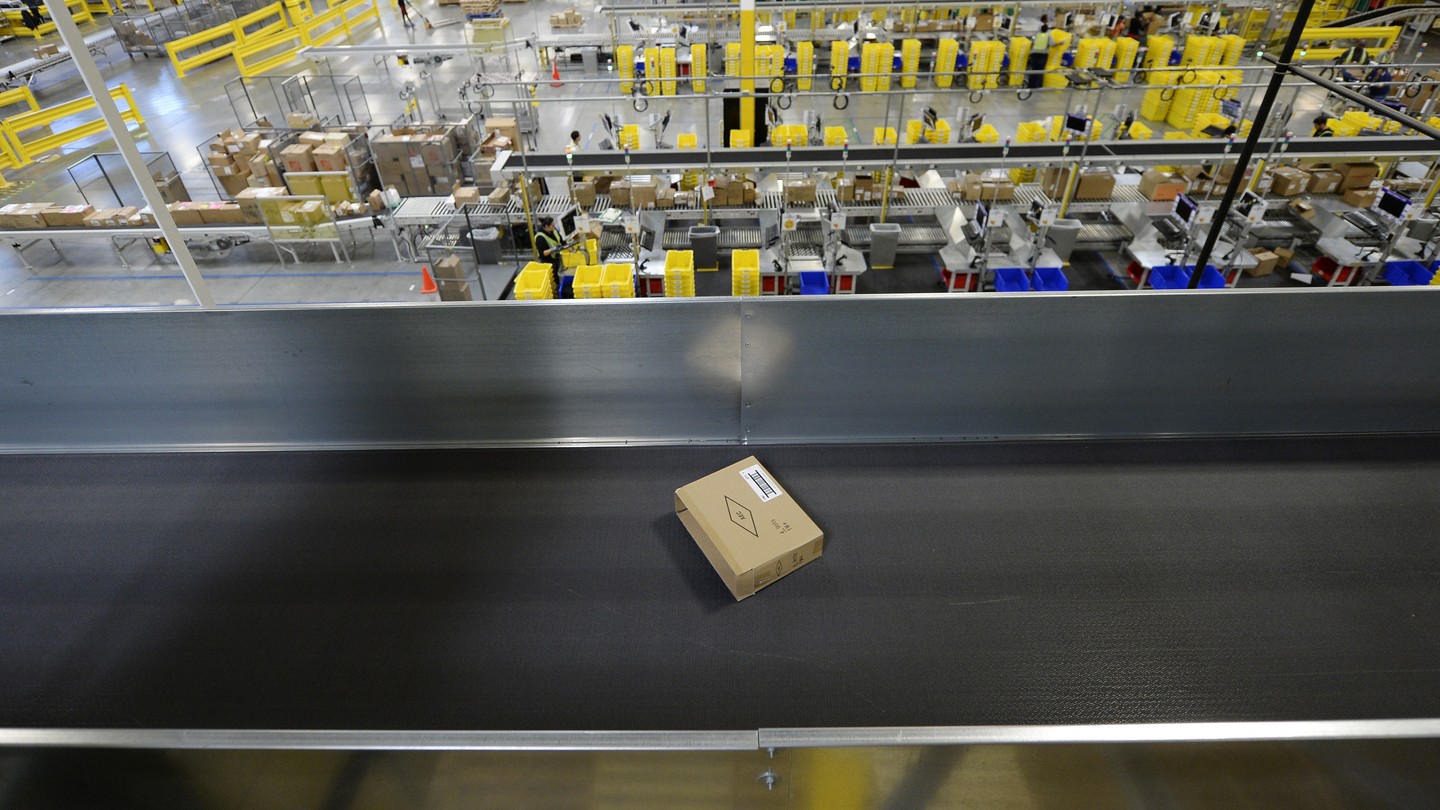 A cardboard box on a conveyor belt inside a warehouse