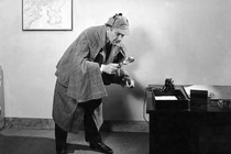 A detective looks through a magnifying glass.
