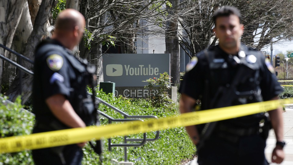 Police officers stand guard outside YouTube headquarters. 