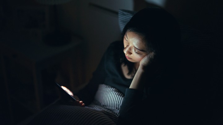 Woman using phone in bed