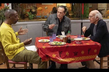 Larry David eating at a restaurant with two friends