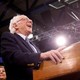 Bernie Sanders laughing at a podium