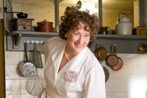 Meryl Streep in a white chef's outfit playing Julia Child