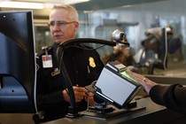 A traveler scans their fingerprints at an airport checkpoint.