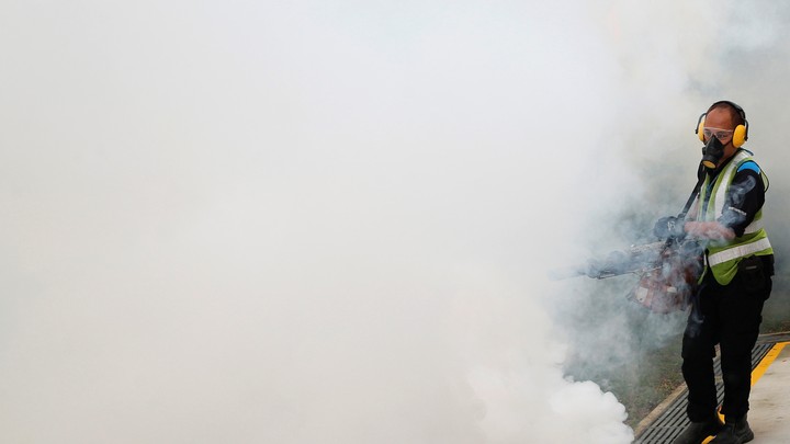 A worker uses insecticide to fog the common area of a public housing estate in Singapore, in an area where 189 cases of locally-transmitted Zika have been reported.