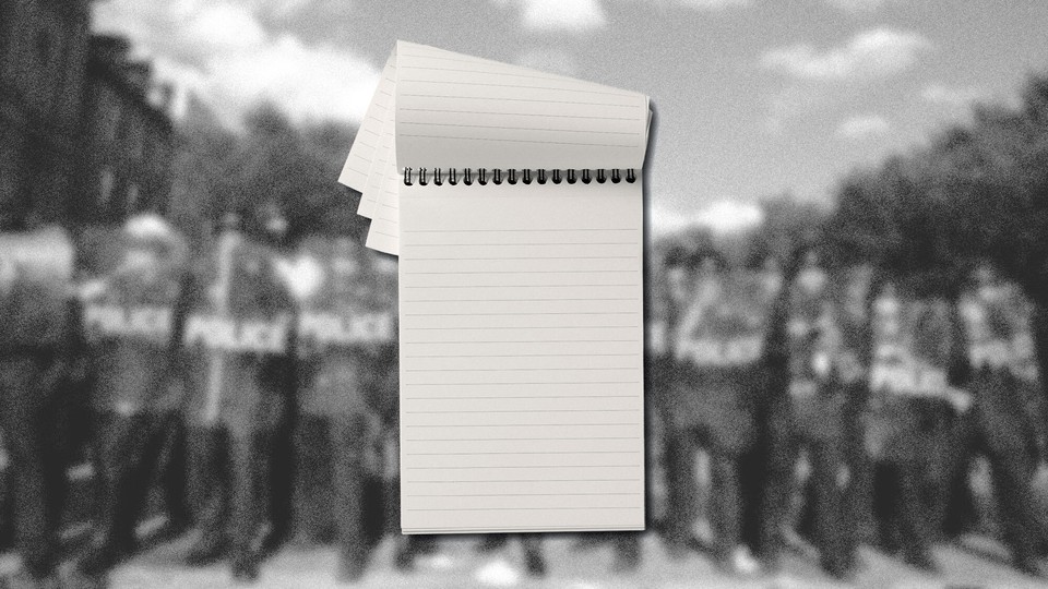 A pad of paper is set against a blurred image of police standing in a line with riot gear.