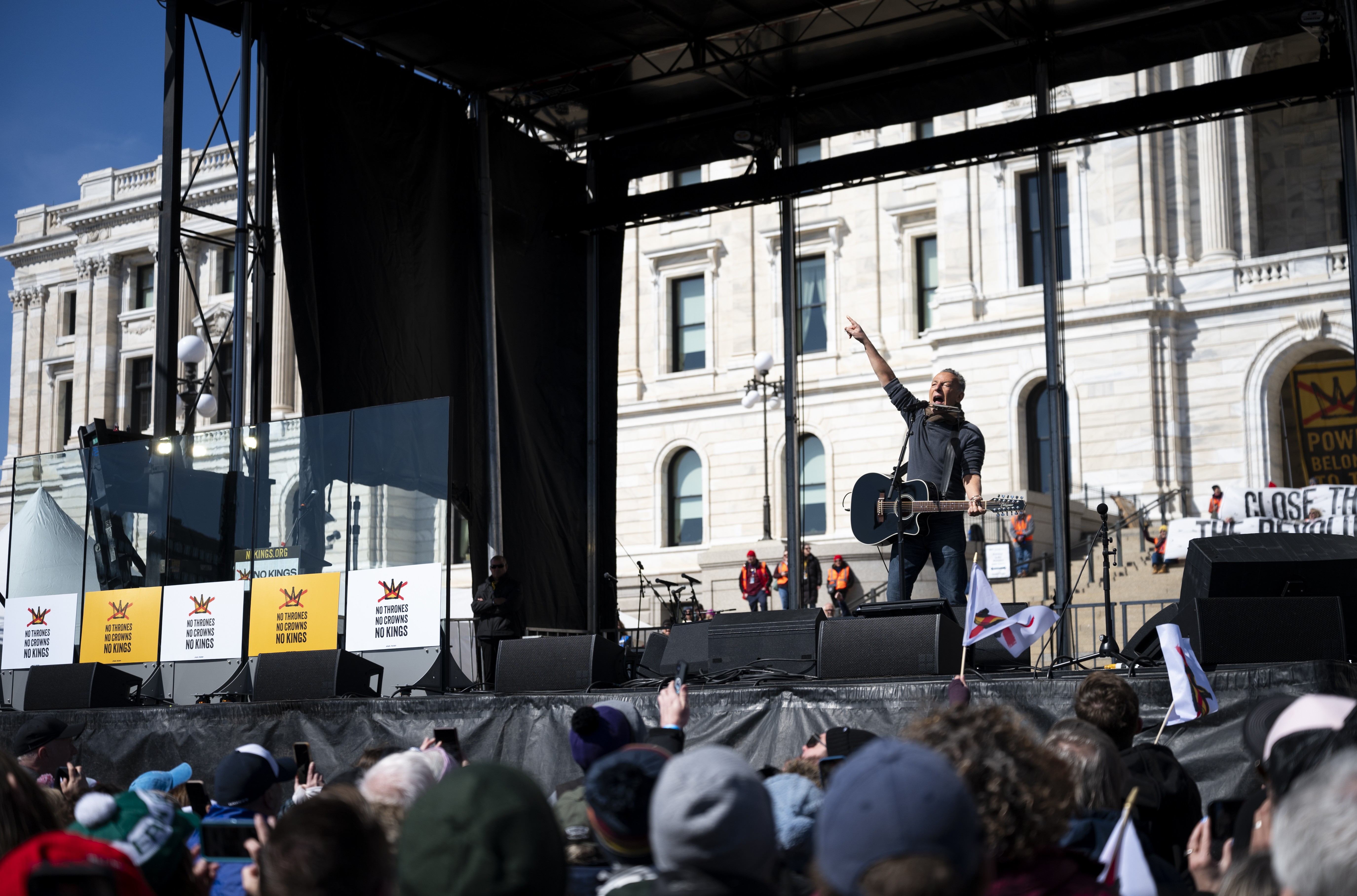 Musician Bruce Springsteen performs in front of a crowd during a protest.