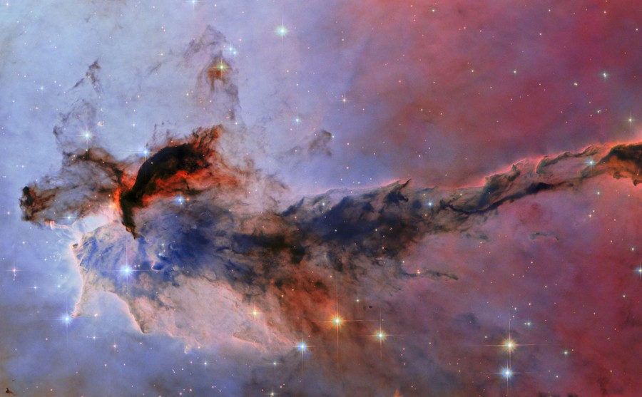Glowing and dark sections of a huge cloud-like structure in space, backdropped by stars