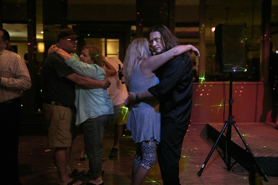 Couple slow dance with lights around them.