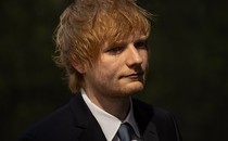 A photo of Ed Sheeran in a suit, looking serious.