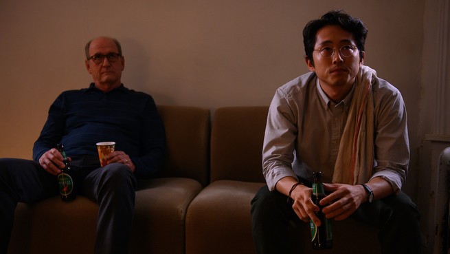 Two men sit on a couch in "The Humans"