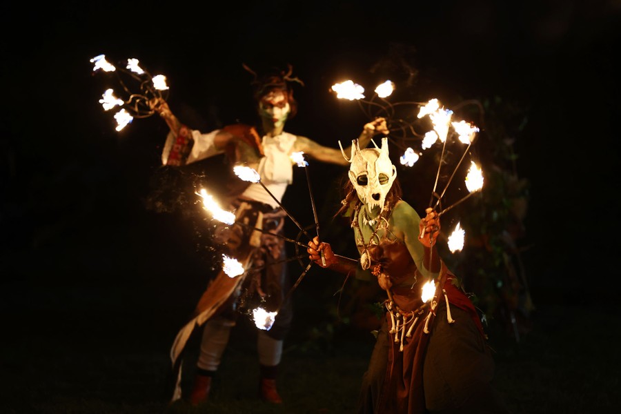 People dance with fire while wearing Pagan costumes.