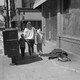 A family walks by a man laid out on the sidewalk