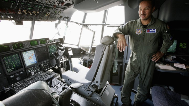 JD Haig, an Air Force Reserve pilot, stands in the cockpit of the Hurricane Hunter WC-130J, in 2007.