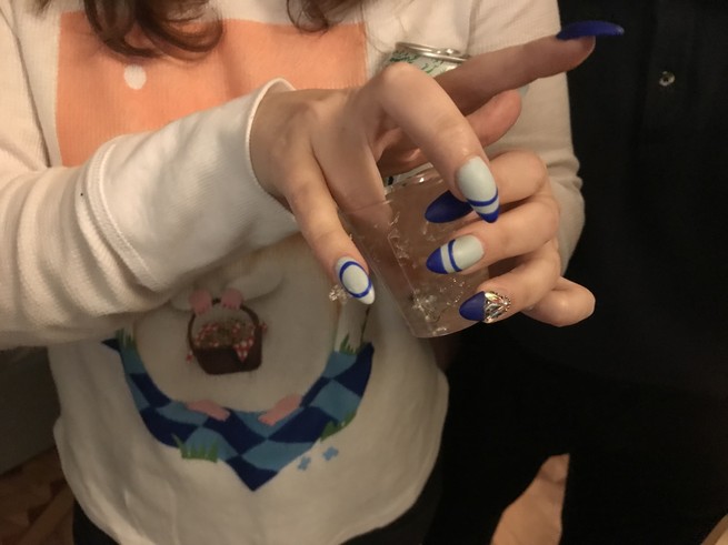 A woman's hand digging into a Jell-O shot. Blue manicure.
