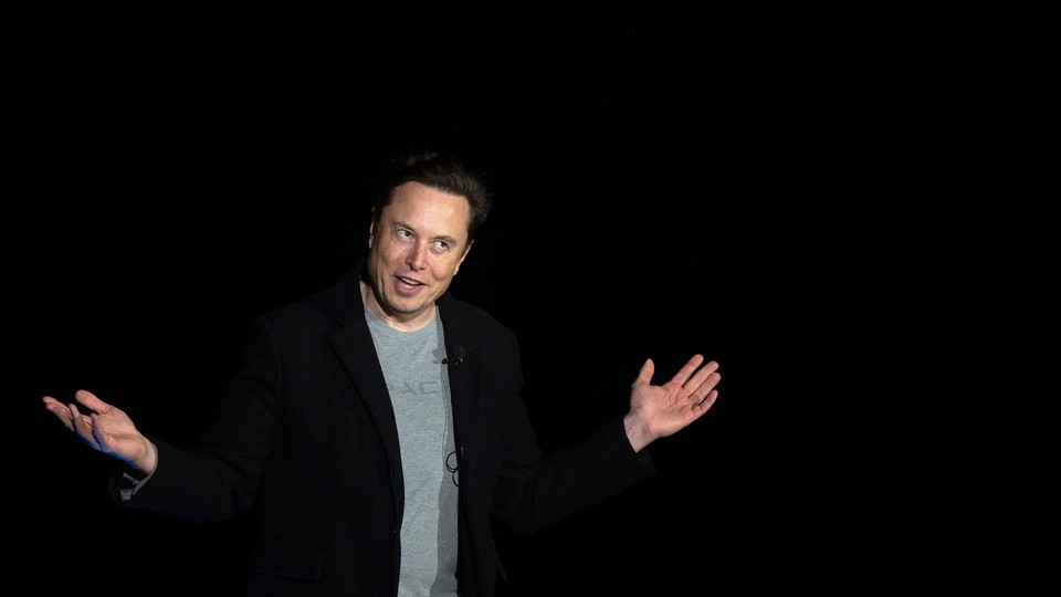 Elon Musk with his mouth half open, his eyes glancing upward, and his arms spread