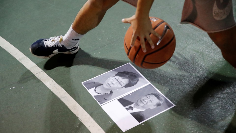 A basketball is dribbled over pictures of President Xi Jinping and Hong Kong Chief Executive Carrie Lam.