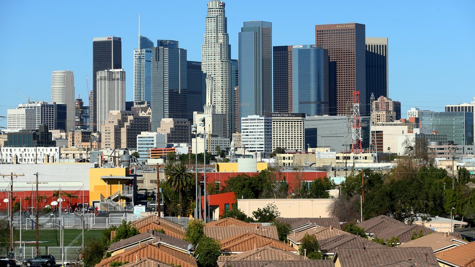 Single-family homes sit in front of the Los Angeles skyline
