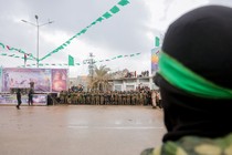 A coffin is paraded before a gathering that includes Hamas members.