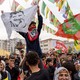 A man holds up a flag of a jailed Kurdish leader at a festival