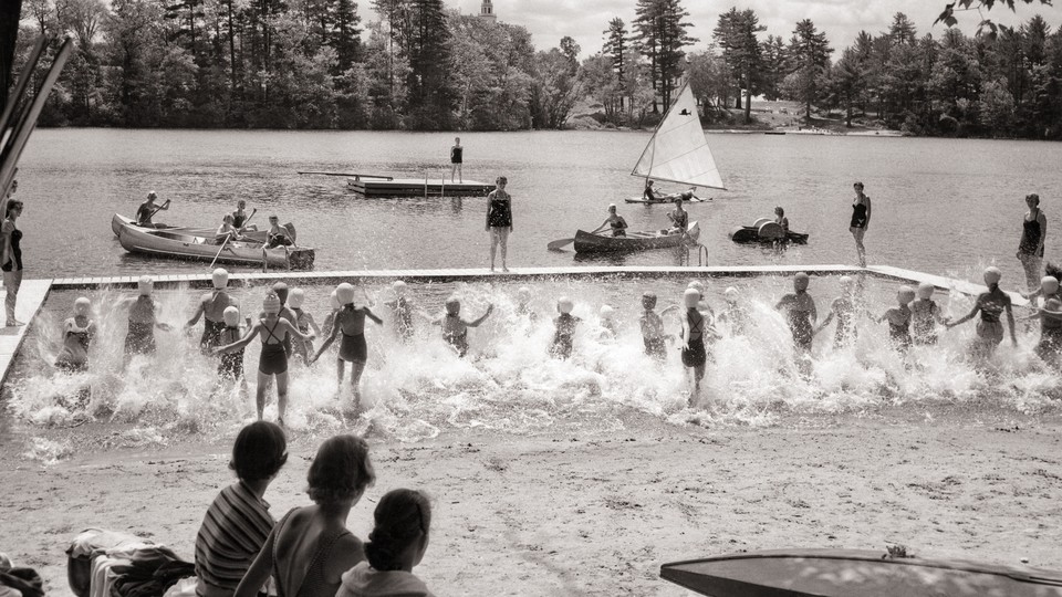 Children splash into the water at camp.