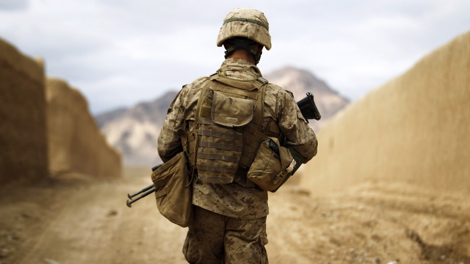 A U.S. Marine with his back to the camera walks through the town of Nabuk in southern Afghanistan.
