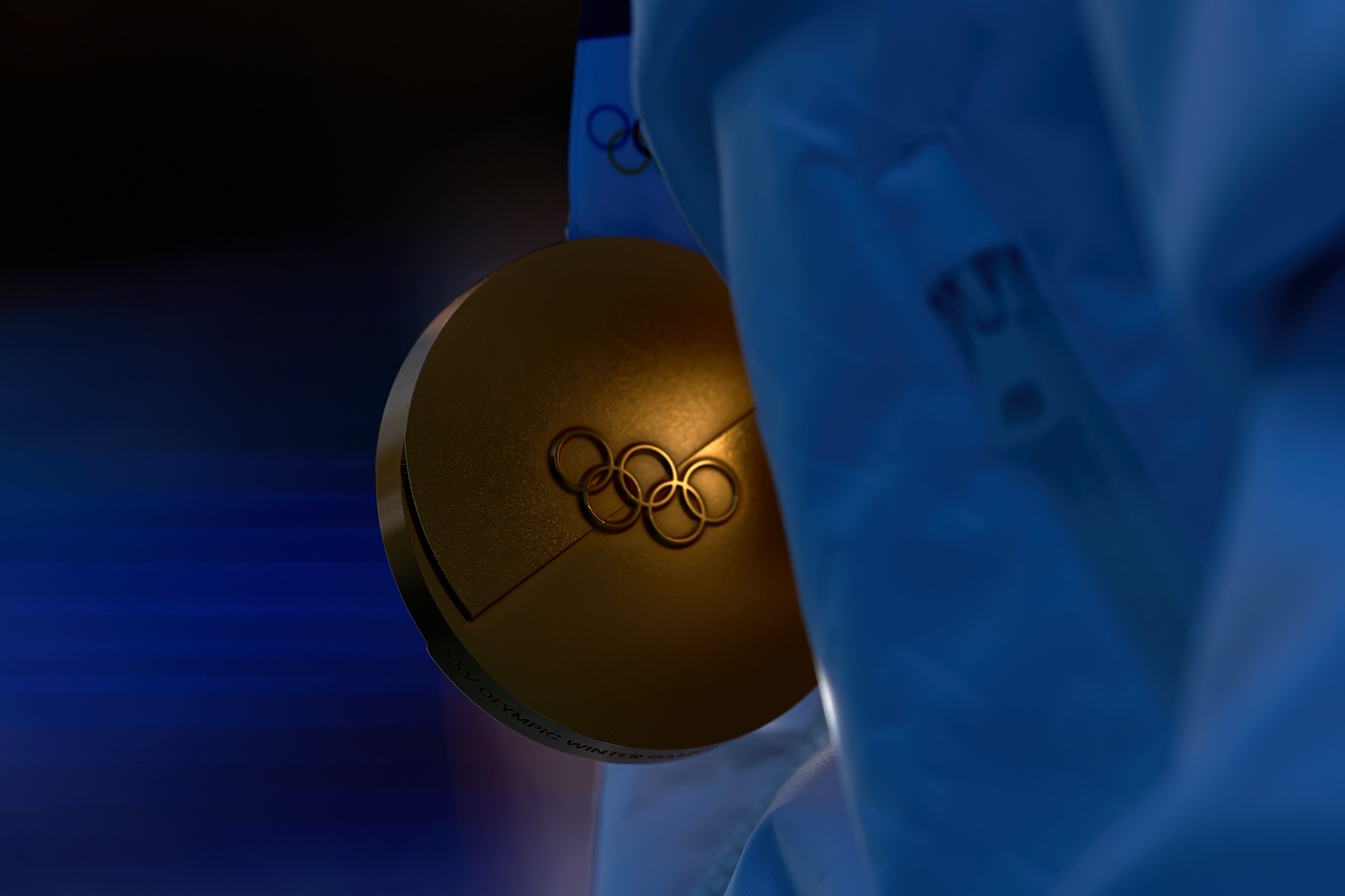 A close view of an Olympic gold medal held by an athlete.