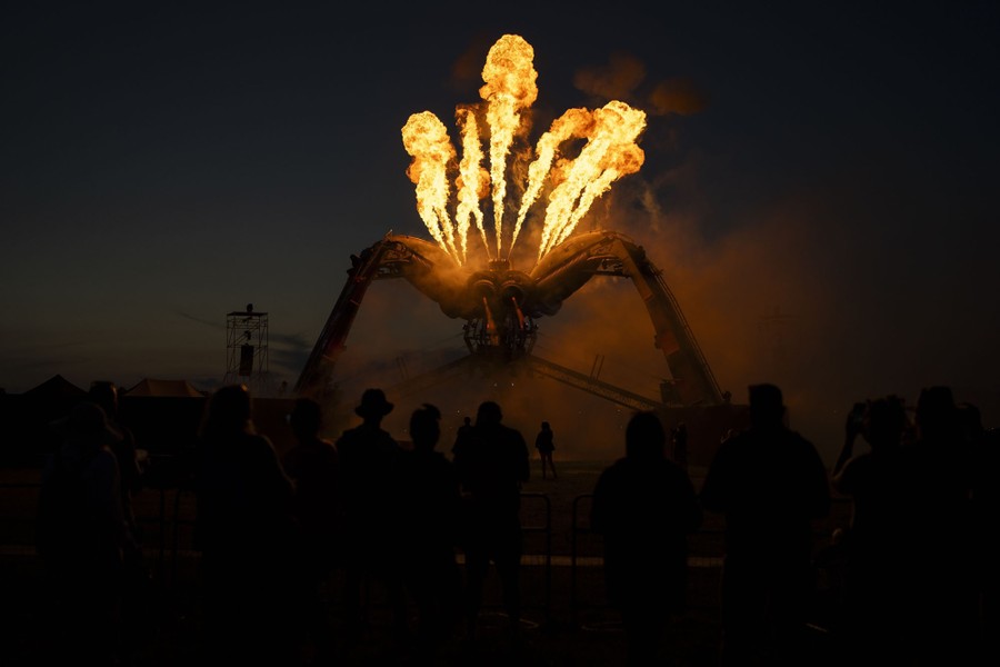 Jets of fire emerge from the top of a large spider-like sculpture.