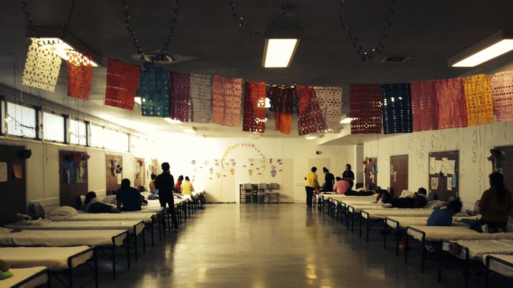 Children's bunk room with colorful flags and approximately 15 children