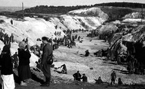 A black-and-white photo of Soviet prisoners of war covering a mass grave at Babi Yar