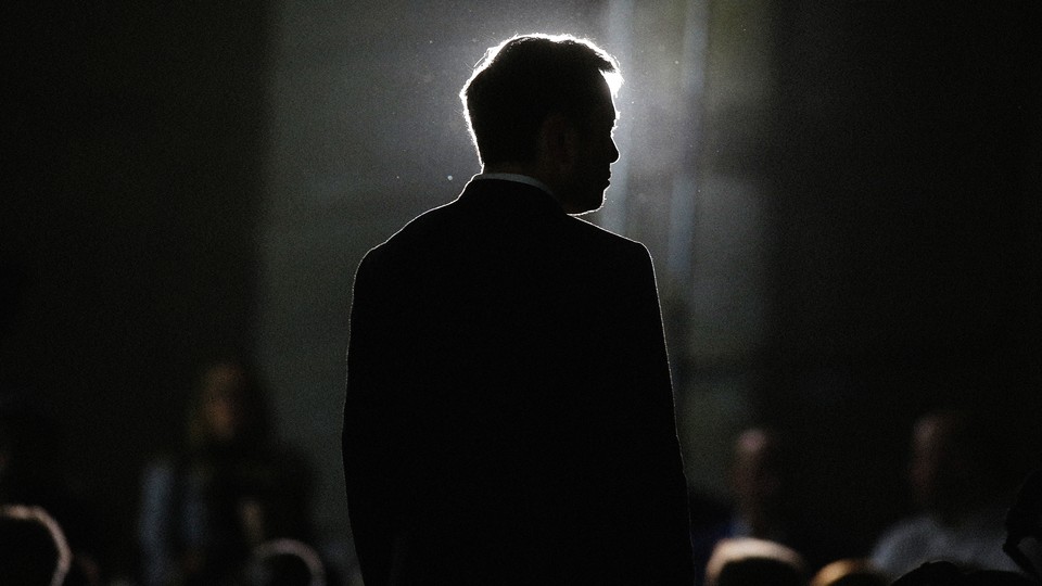A photo of Elon Musk in silhouette captured from behind